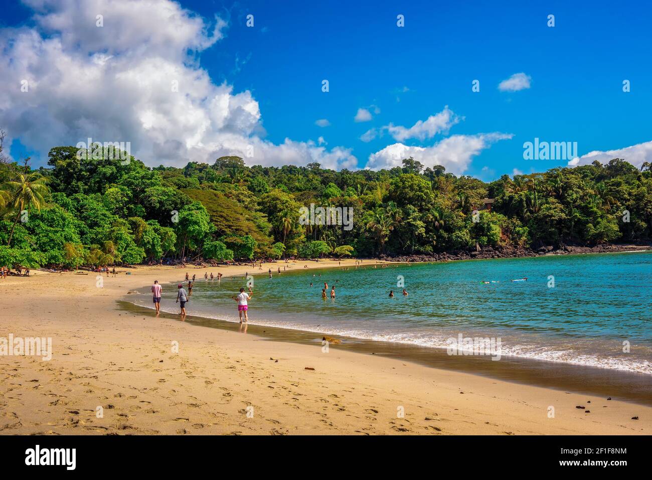 Tropical beach in Manuel Antonio National Park with tourists in Costa Rica Stock Photo