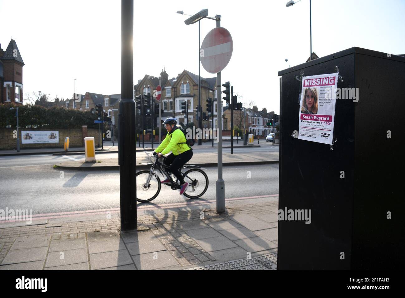 A woman cycles past a missing poster along the A205 Poynders Road, at the junction with Cavendish Road in Clapham, south London, after new CCTV of missing woman Sarah Everard, 33, was discovered. Sarah left a friend's house in Clapham, south London, on Wednesday evening at around 9pm and began walking home to Brixton. Picture date: Monday March 8, 2021. Stock Photo