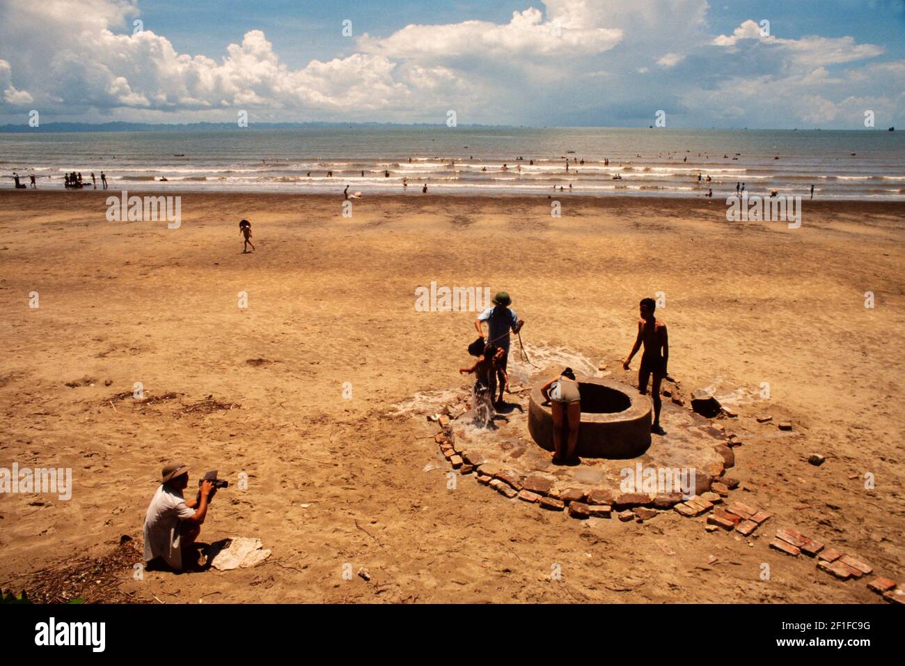 Locals enjoy the beach and sea at a coastal resort, North Vietnam, June 1980 Stock Photo