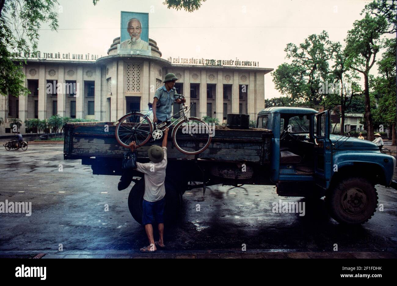 Unloading a bike from a truck outside a government building, Hanoi, North Vietnam, June 1980 Stock Photo