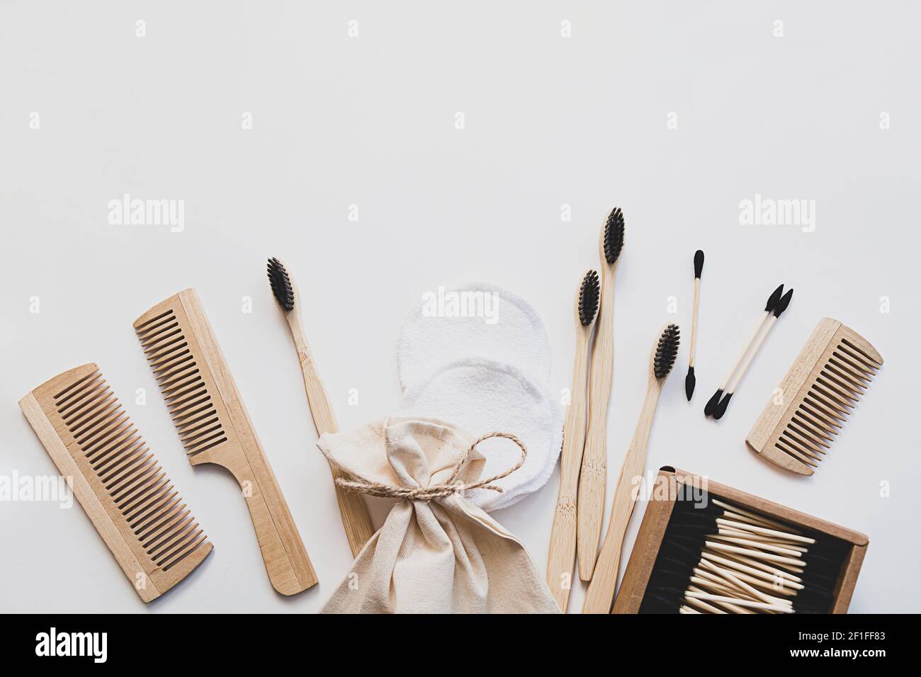 Eco-friendly bamboo toothbrushes, ear sticks, reusable cotton sponges and wooden combs are bathroom products. Zero waste concept. Composition on white Stock Photo