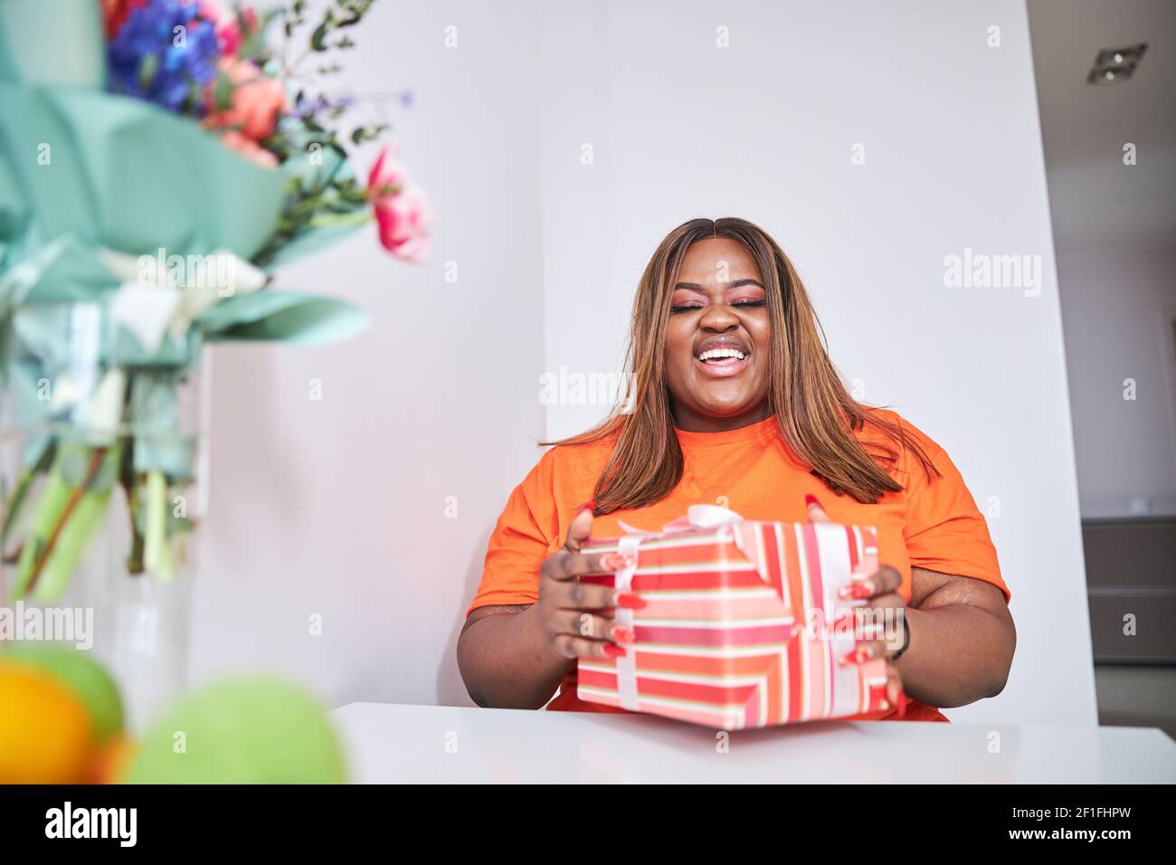 Plus Model Gift Happy plus-size woman posing with a special gift Stock Photo - Alamy
