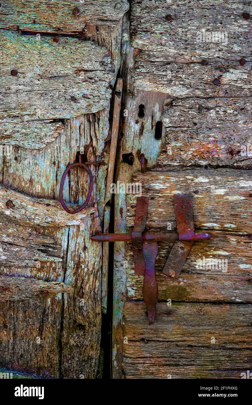 Detail of an old barn door showing the bolt and handle in a closed position Stock Photo