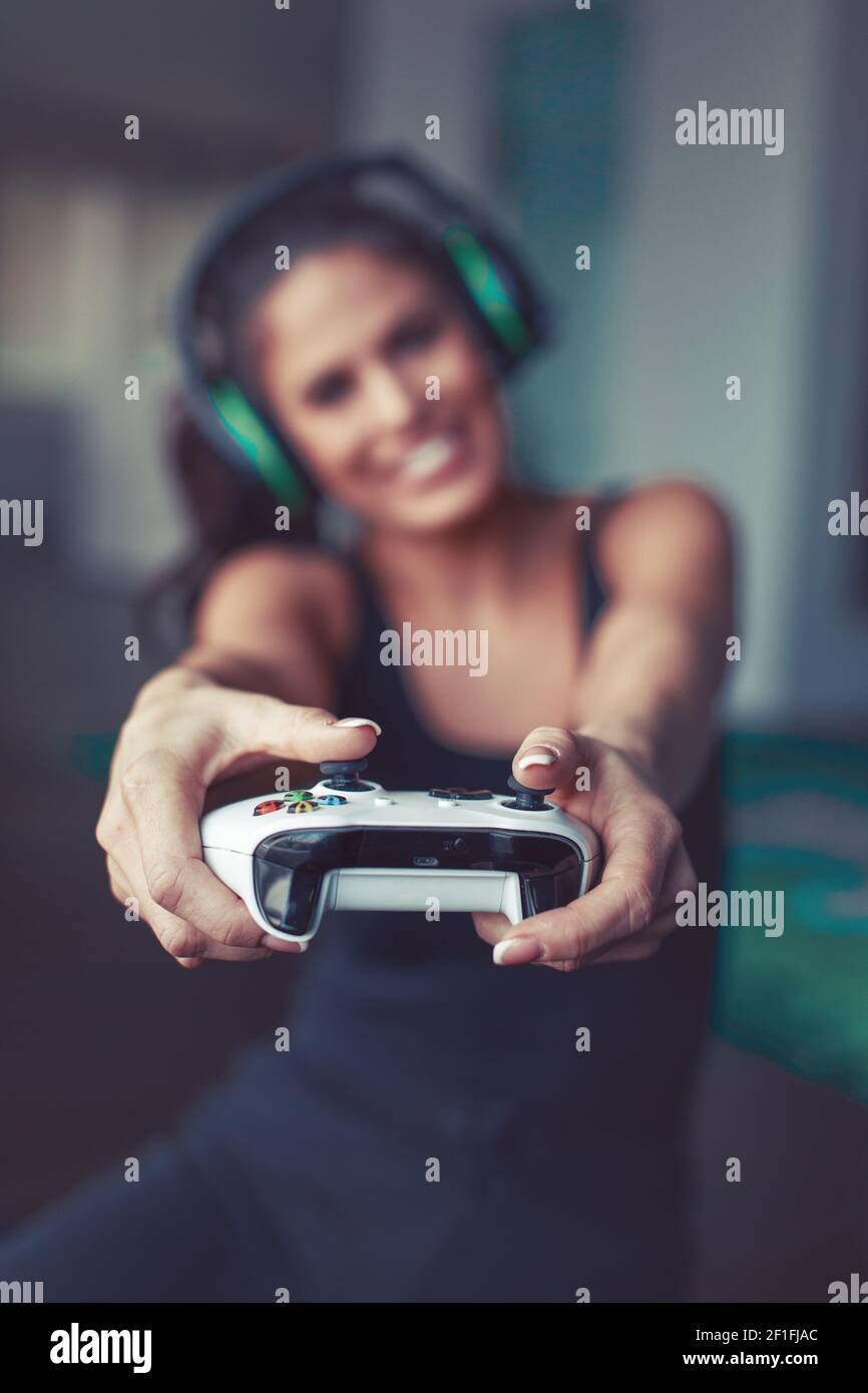 Happy young Caucasian woman playing console game , depth of field Stock Photo
