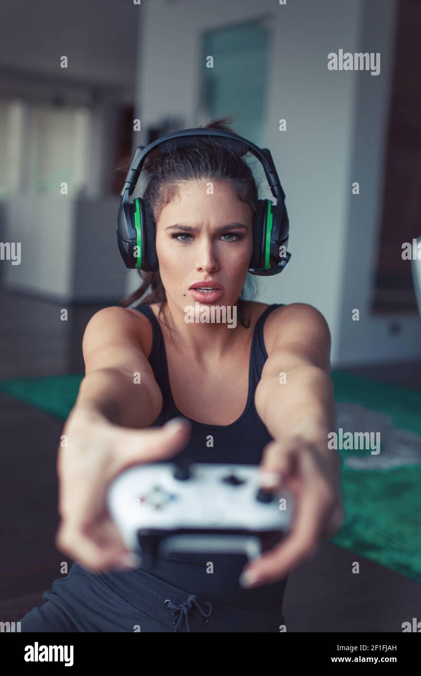 Young focused gamer woman playing on console video game, selective focus Stock Photo