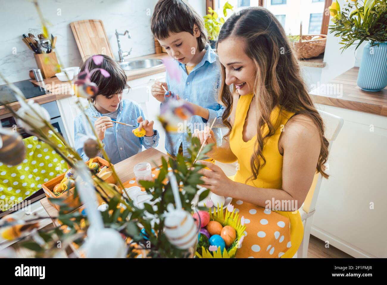 Mother and sons coloring eggs for Easter Stock Photo