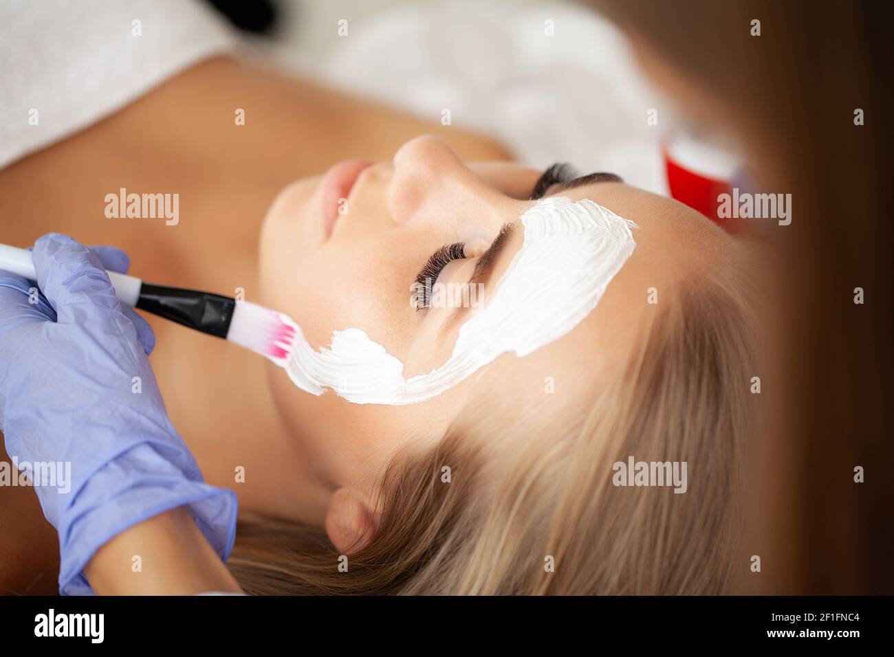 Attractive funny woman with a clay mask on her face Stock Photo - Alamy