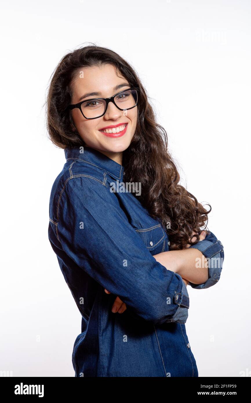 Portrait of a young confident woman with long wavy hair and glasses in ...