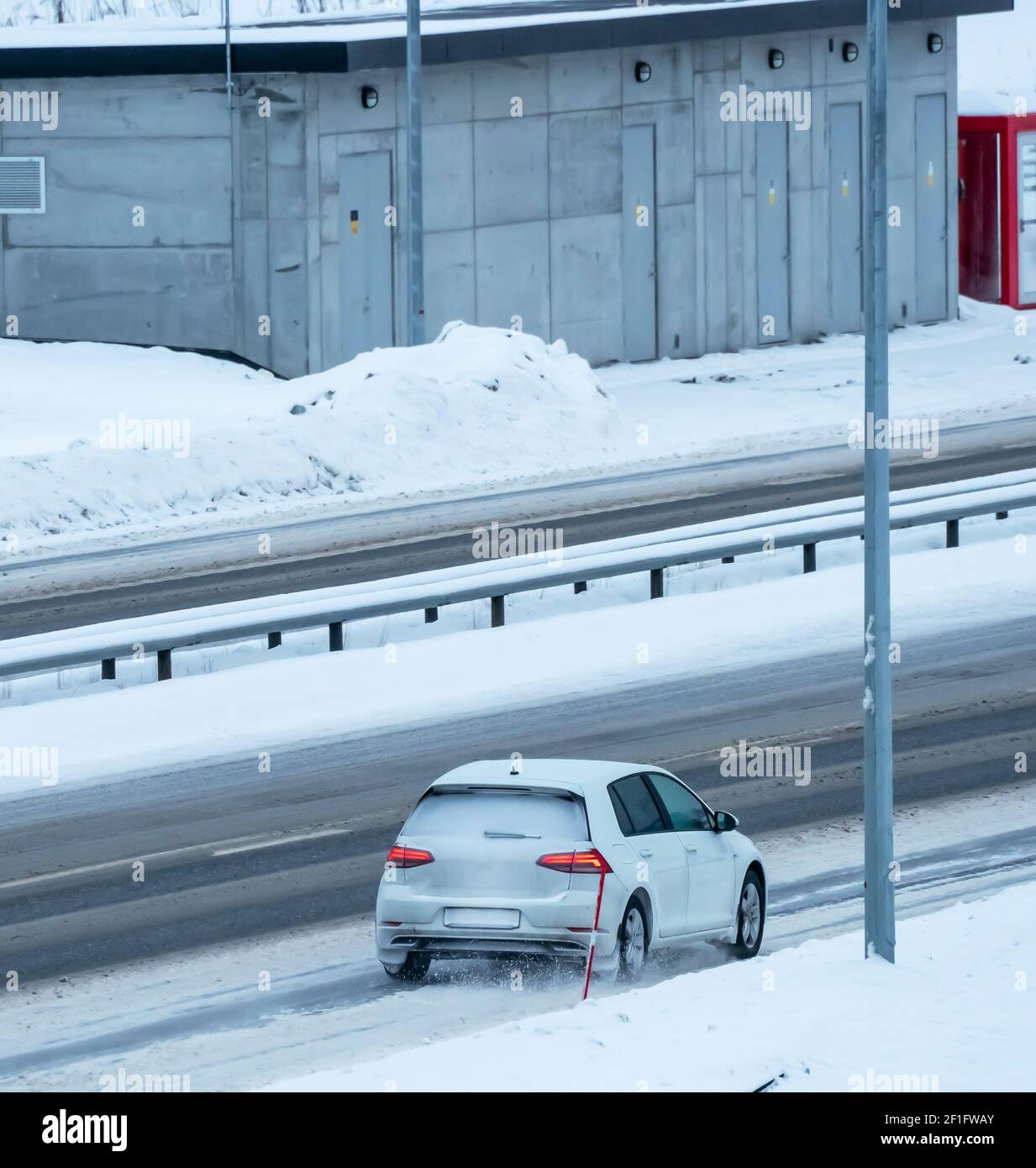Cars driving on a highway in a blizzard with the road covered in snow ...