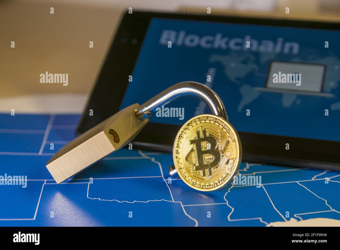 Bitcoin and open padlock over a US map and a screen with blockchain ...