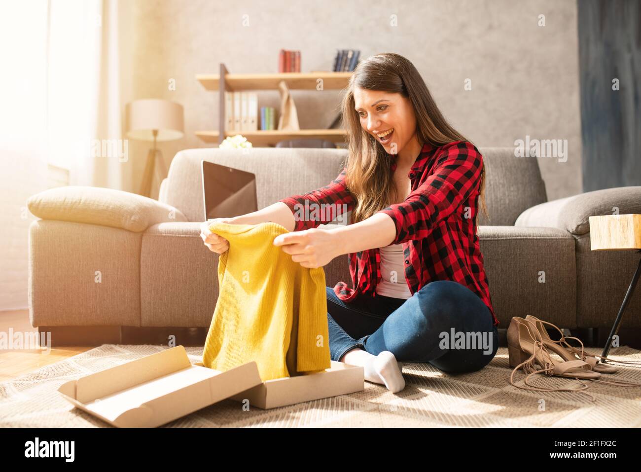 Happy girl has received a package of an online ordered Stock Photo