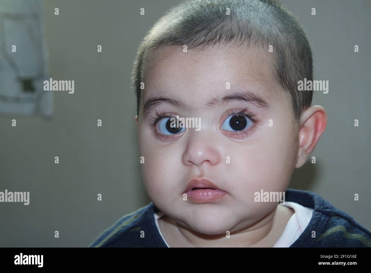 Baby girl with lovely face, big eyes and cute face gesture. Toddler baby making sweet activities Stock Photo