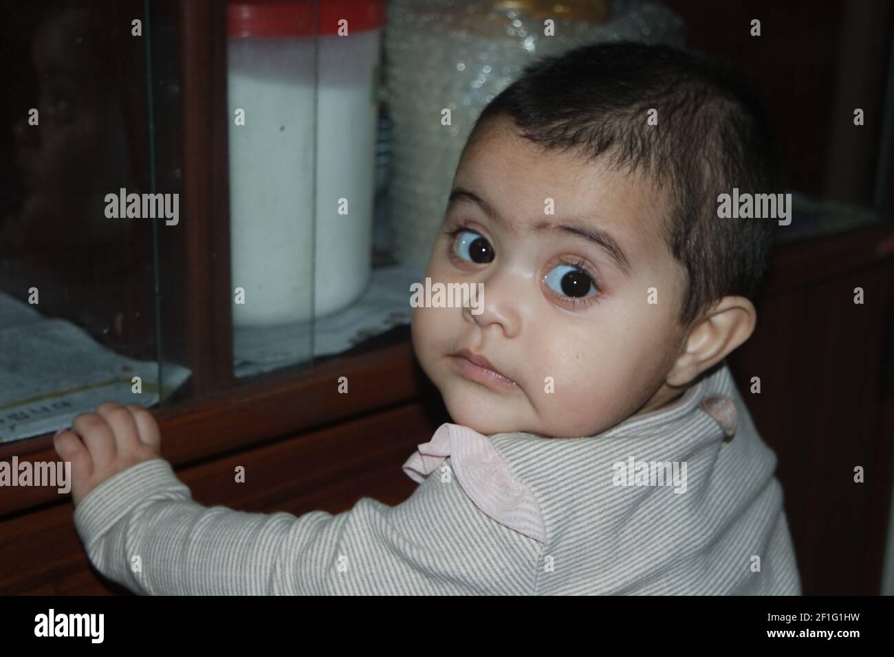 Baby girl with lovely face, big eyes and cute face gesture. Toddler baby making sweet activities Stock Photo