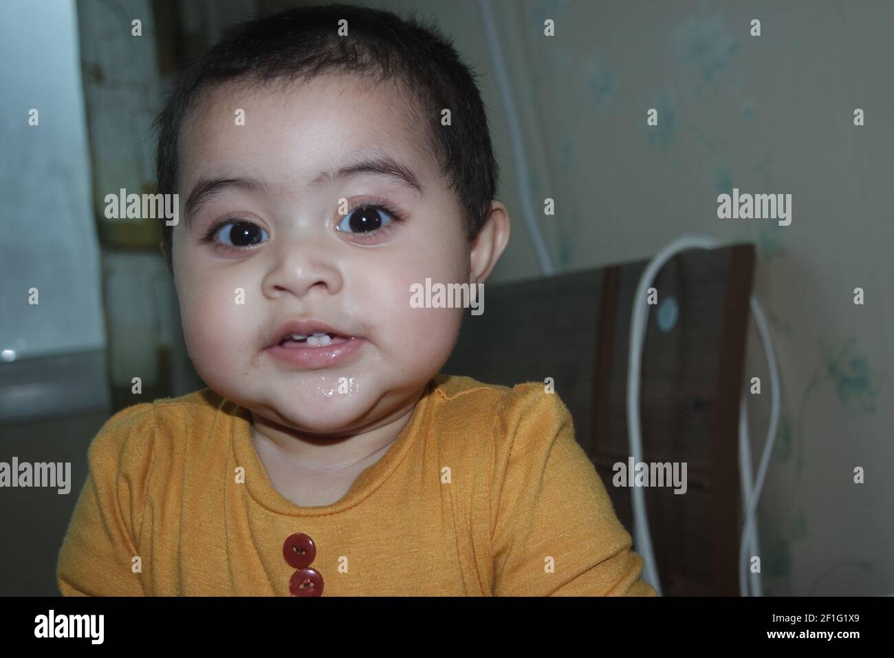 Baby girl with lovely face, big eyes and cute face gesture. Toddler baby making sweet activities Stock Photo