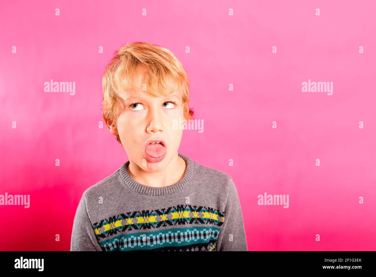 Young child boy making strange faces, rolling his eyes in a grotesque way. Stock Photo