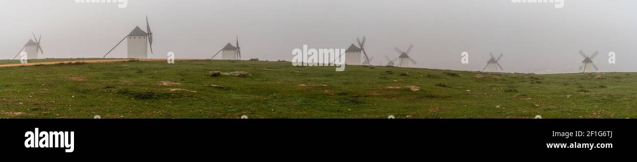 A panorama view of the windmills of Campo de Criptana in La Mancha on a very foggy morning Stock Photo