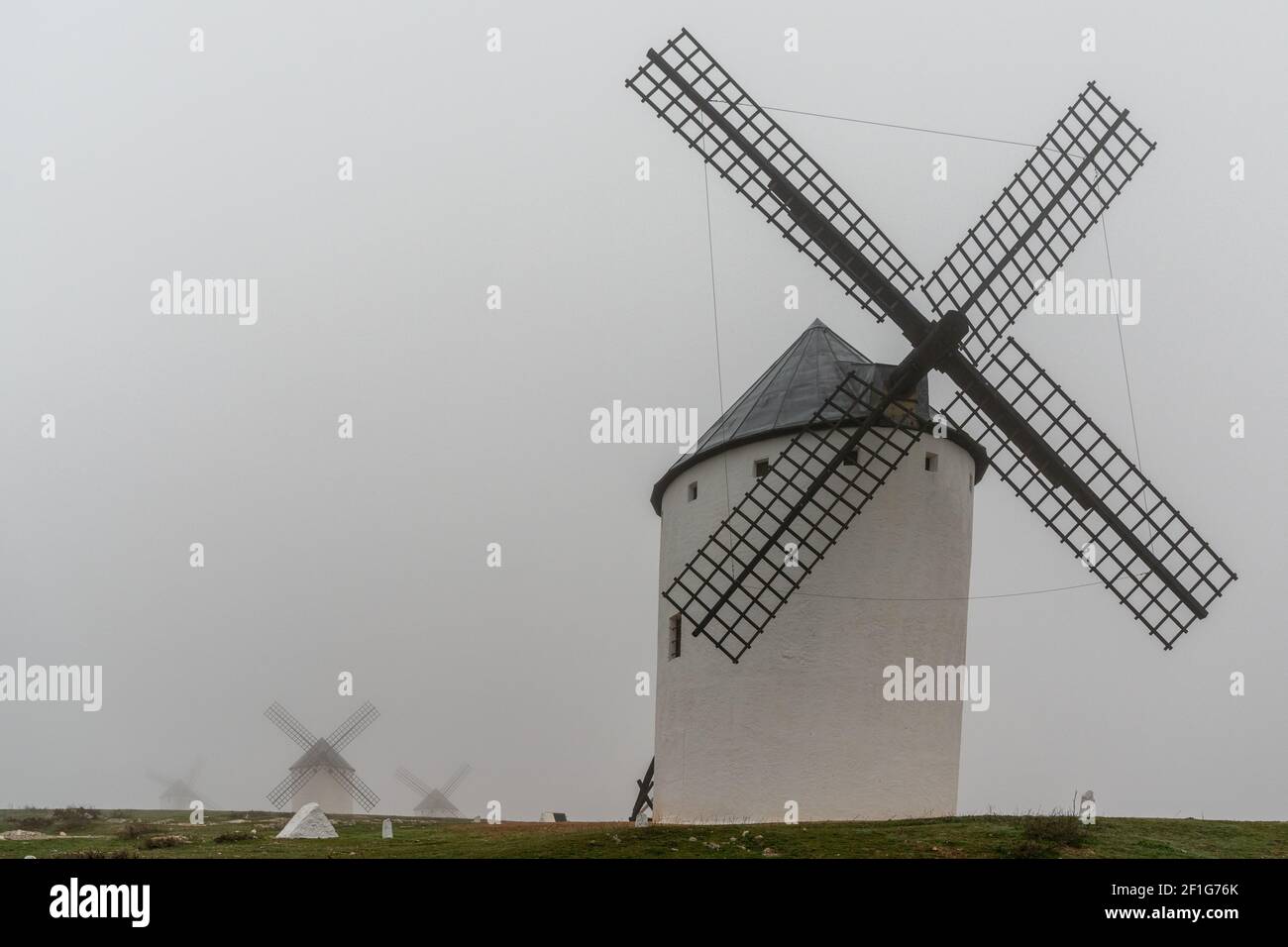 A view of the windmills of Campo de Criptana in La Mancha on a very foggy morning Stock Photo