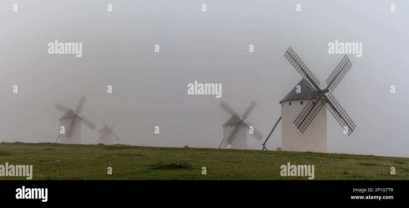 A panorama view of the windmills of Campo de Criptana in La Mancha on a very foggy morning Stock Photo