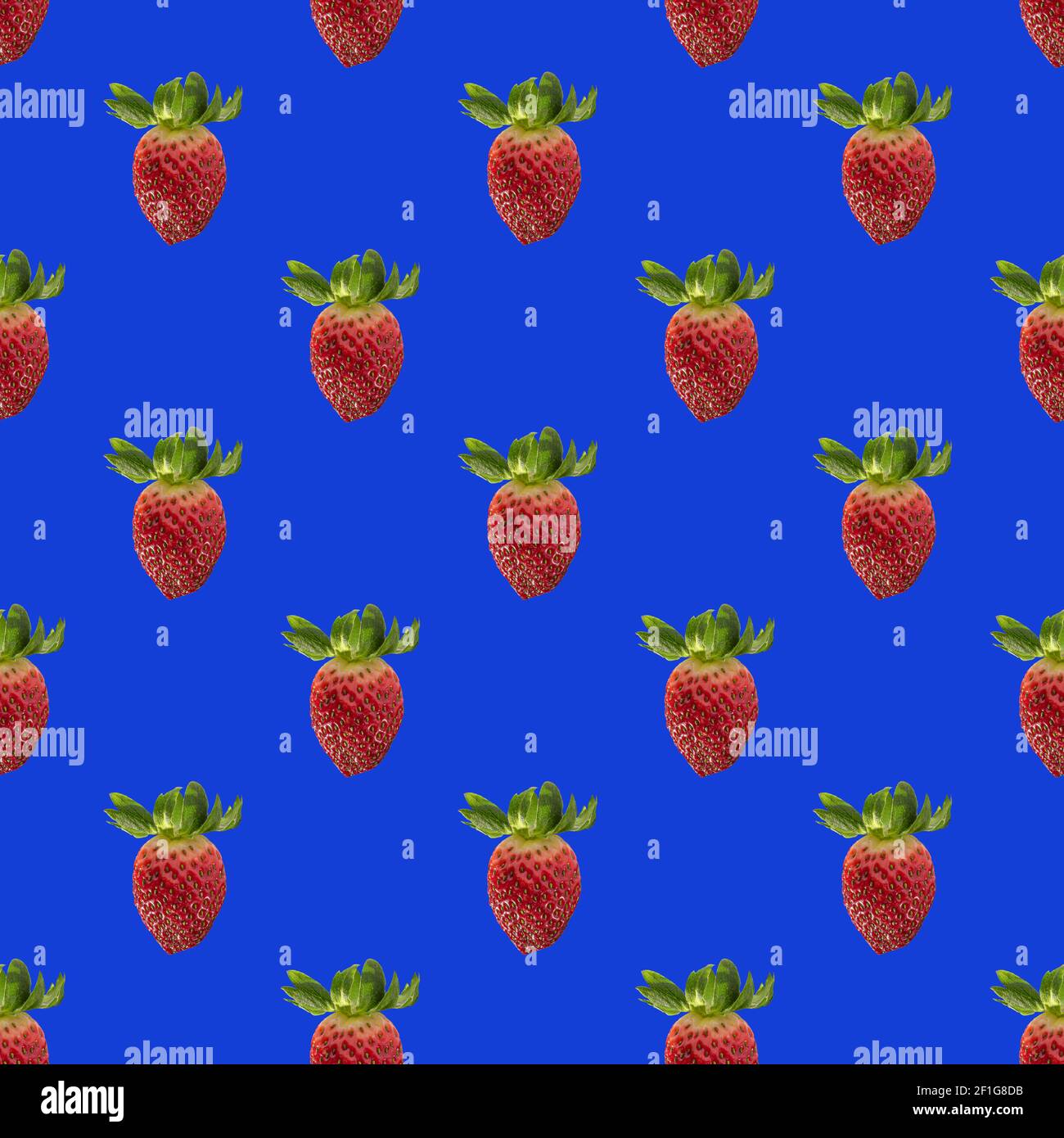Seamless pattern with whole fresh beautiful red strawberries on solid bright blue background. Strawberries in rows. Stock Photo
