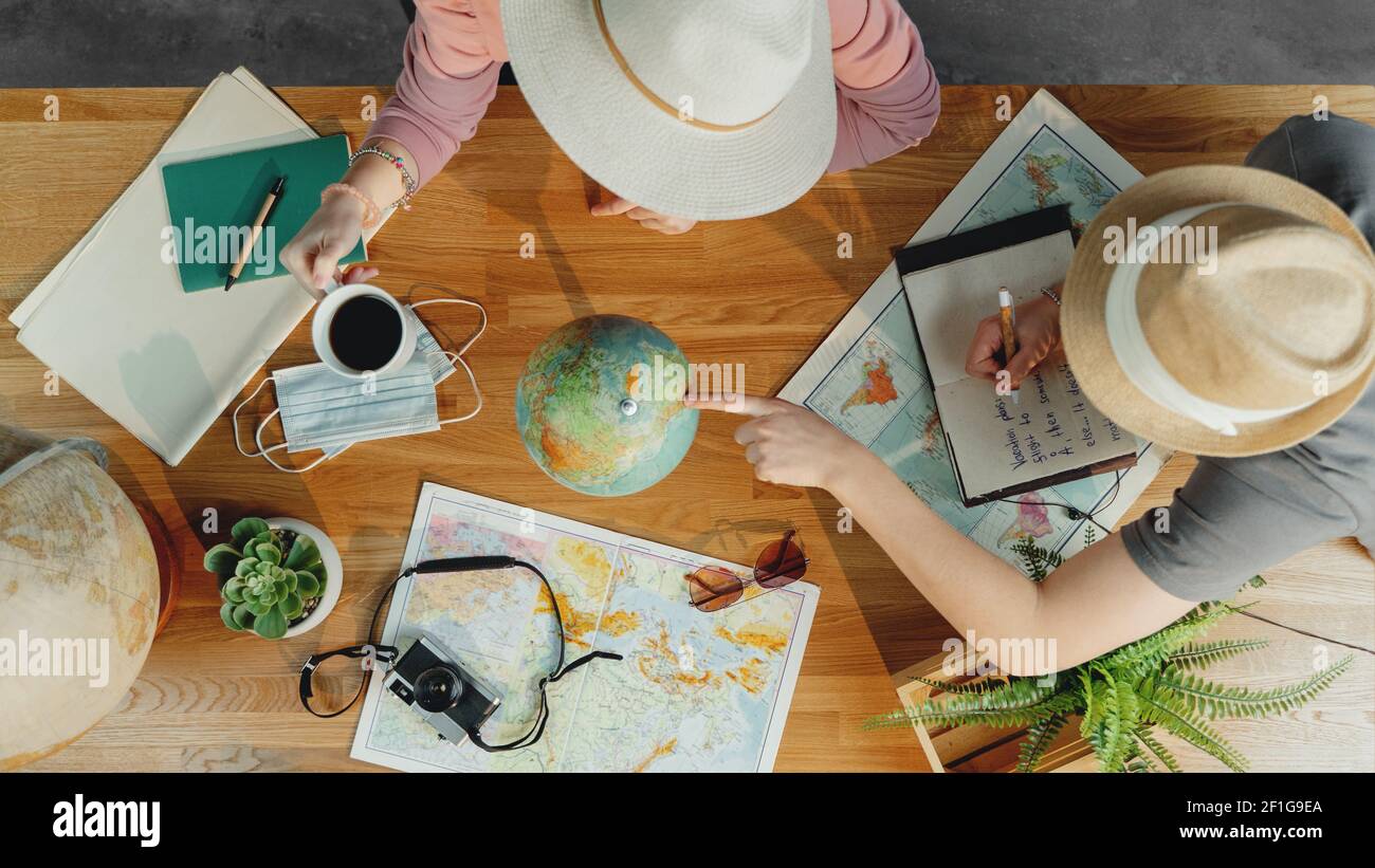 Top view of young couple with maps planning vacation trip holiday, desktop travel concept. Stock Photo