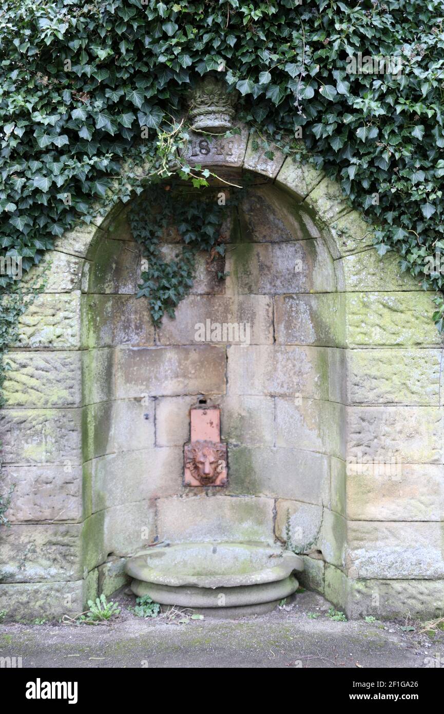 Victorian era stone well dated 1841 opposite the famous Peacock Hotel at Rowsley village in the Derbyshire Peak District Stock Photo