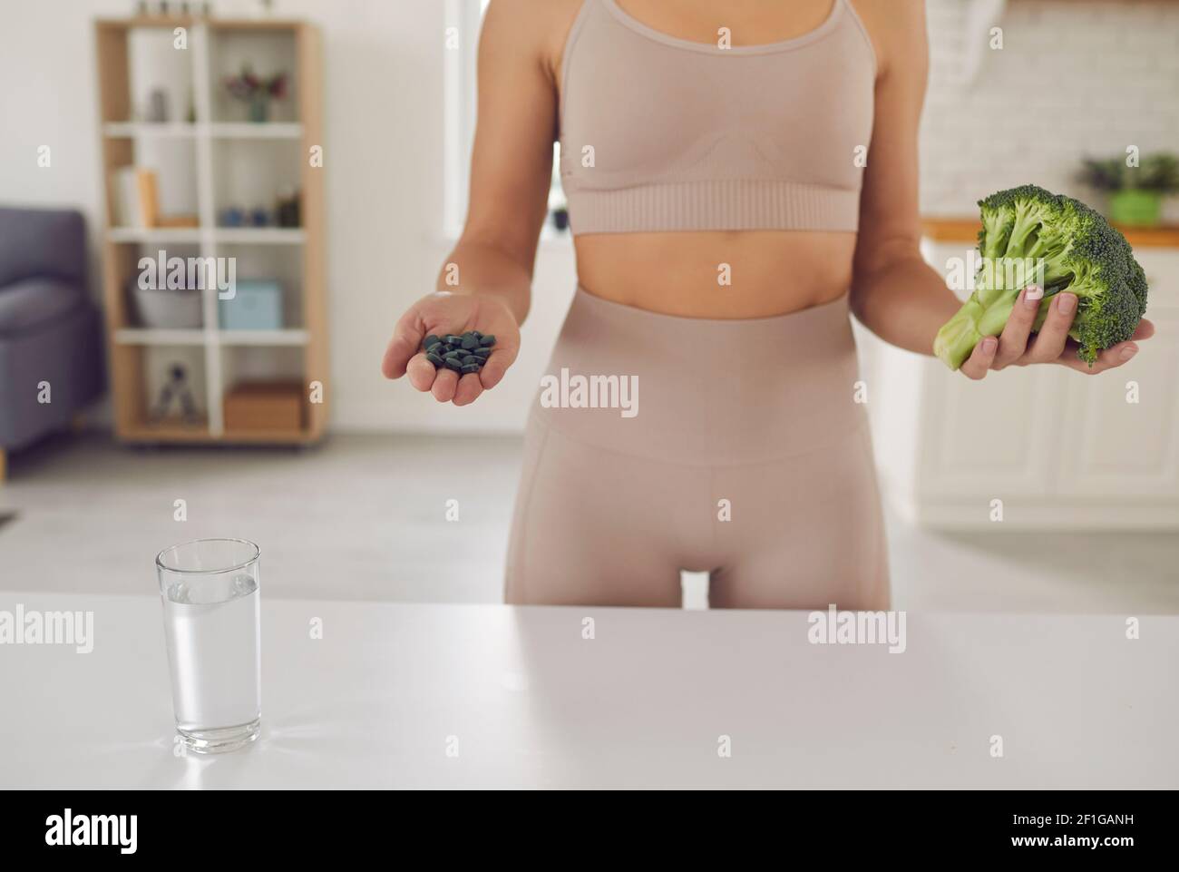 Body and hands of fitness woman athete in sportswear standing holding fresh healthy ingredients Stock Photo