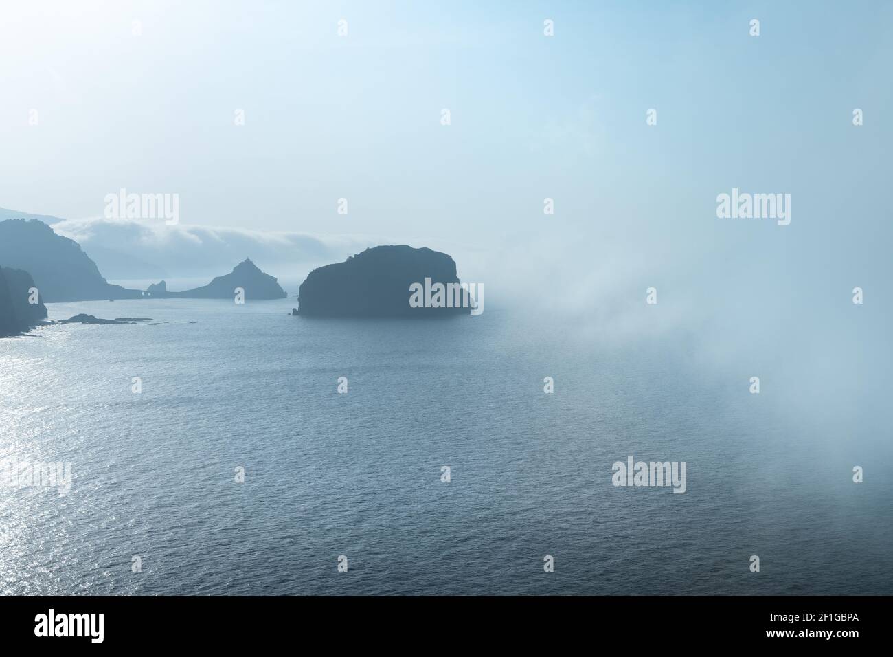 Gaztelugatxe from Machichaco Cape on a foggy day, Basque Country in Spain Stock Photo