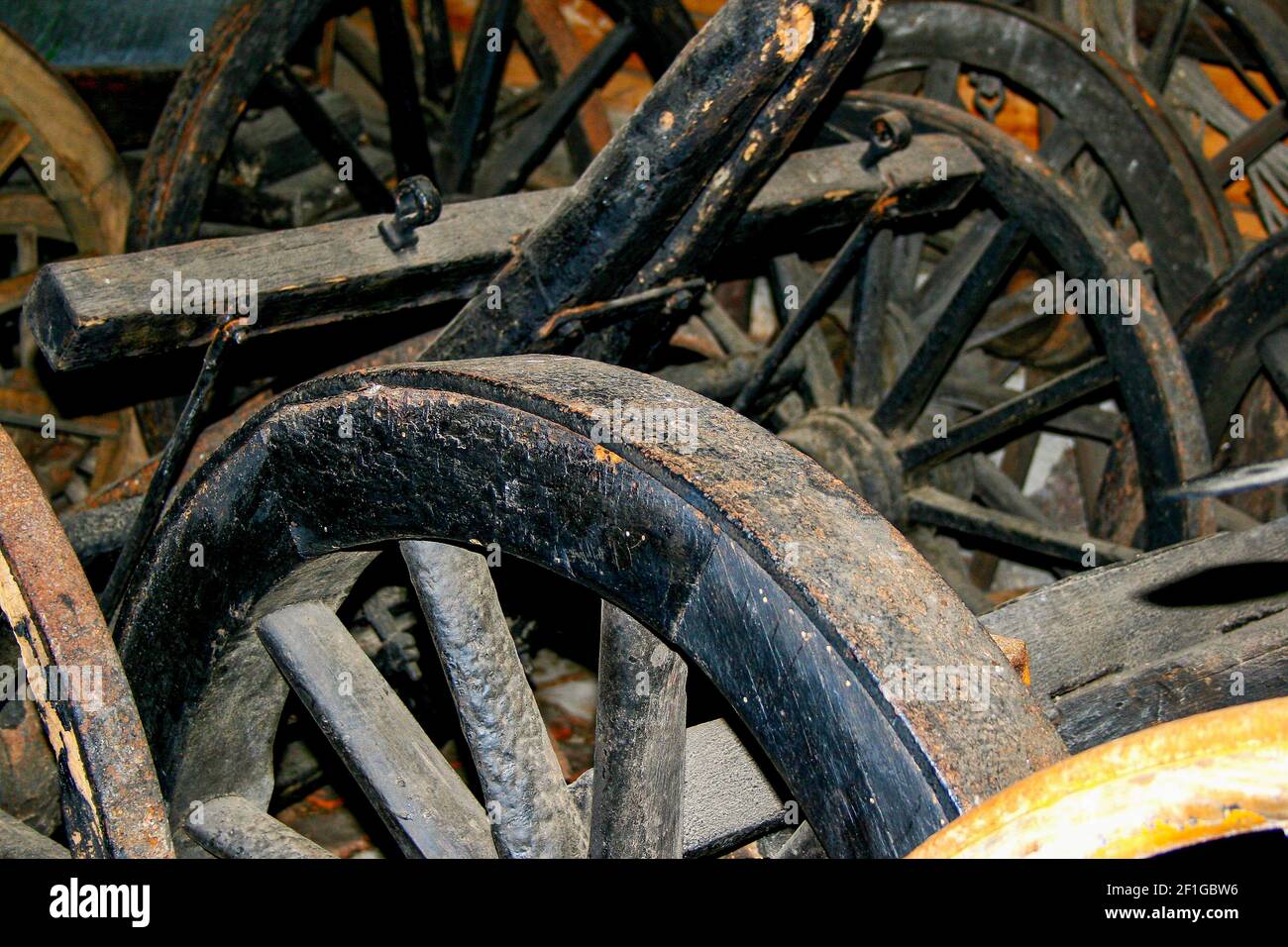 A closeup of old carriages and wagon wheels in a barn Stock Photo