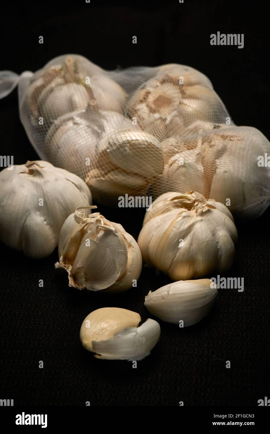Garlic, head of garlic on a dark background with slight blur, mesh of garlic Stock Photo