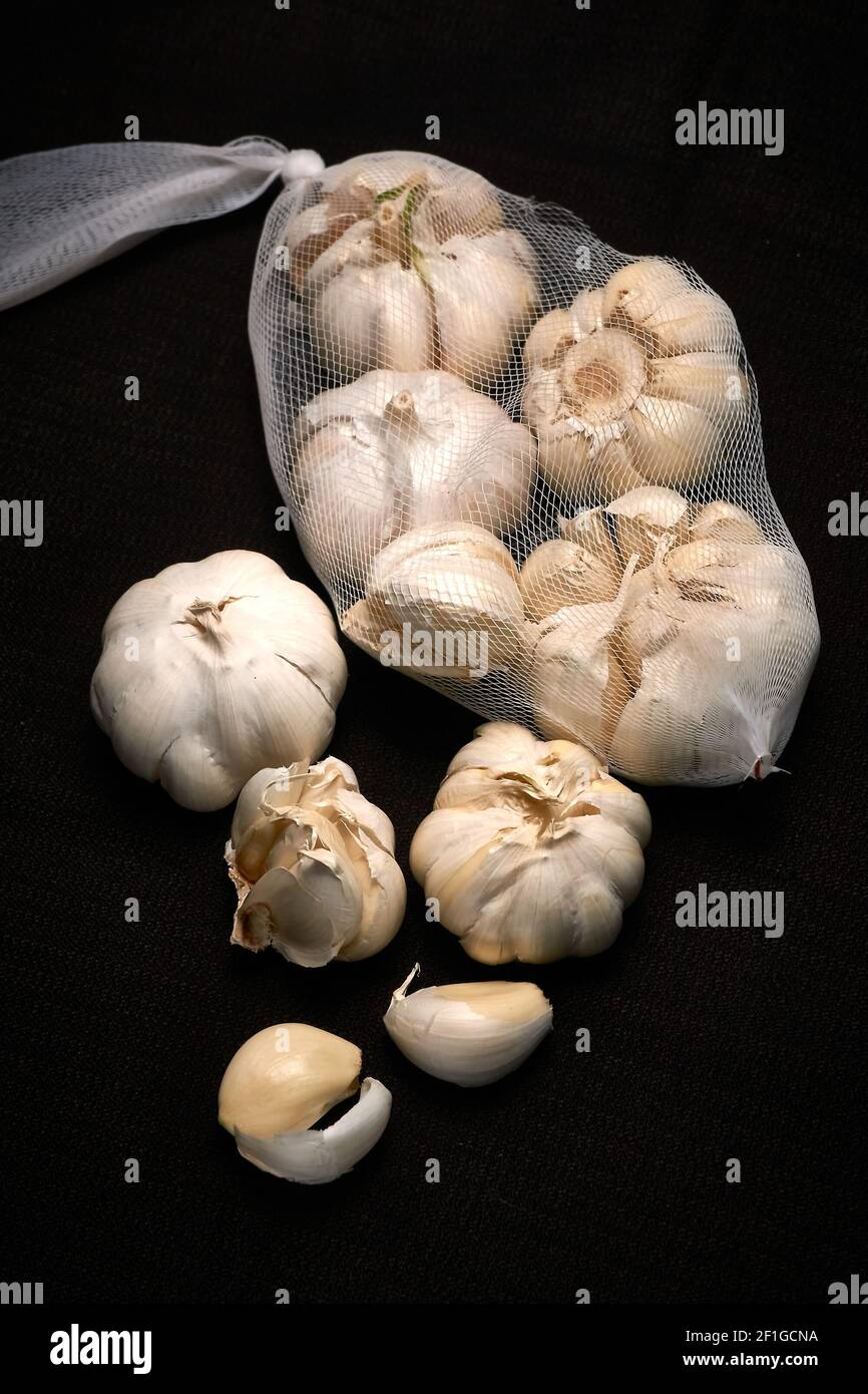 Garlic, head of garlic on a dark background with slight blur, mesh of garlic Stock Photo