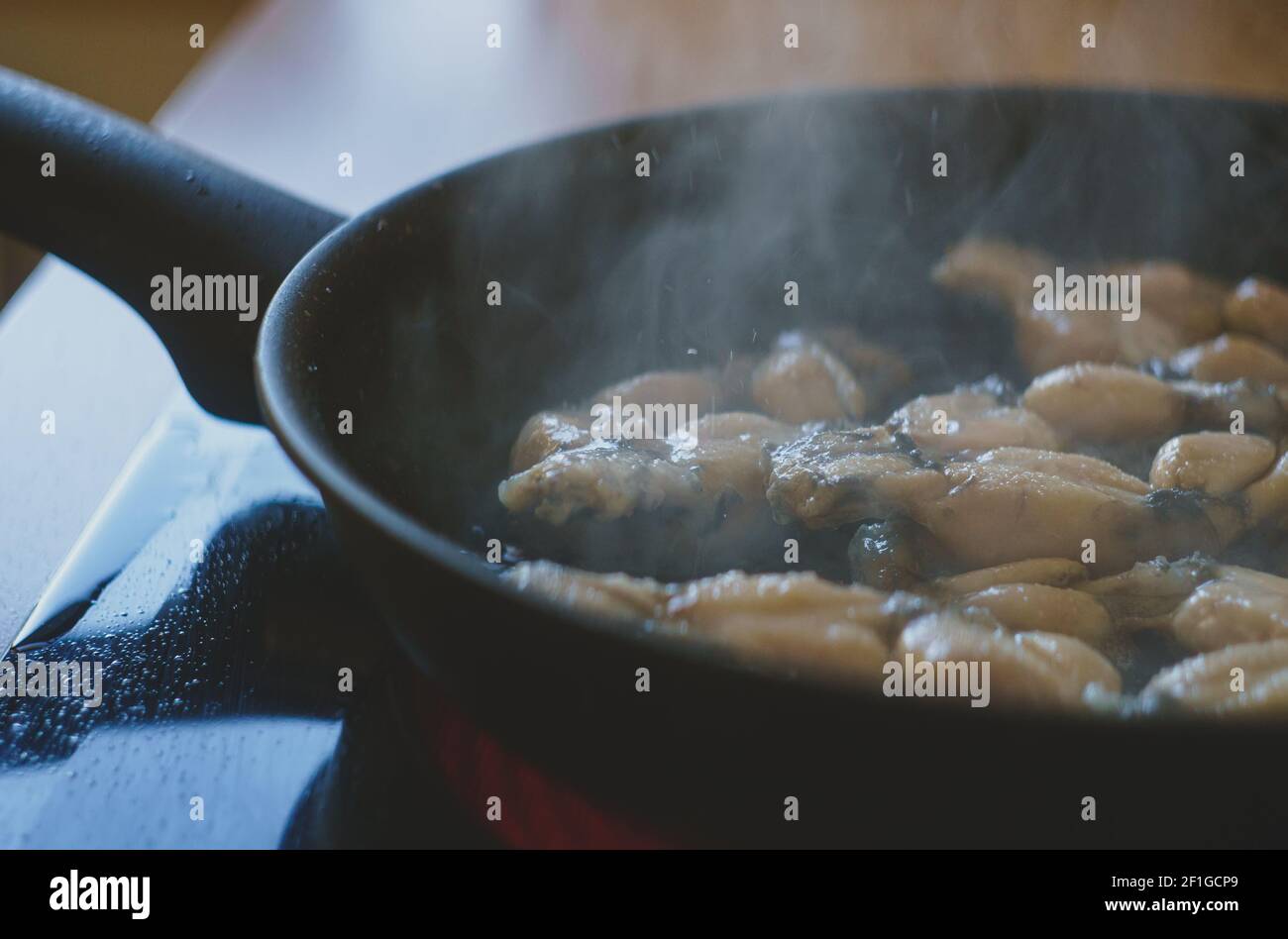 Traditional cooking of fried frog legs on pan Stock Photo Alamy