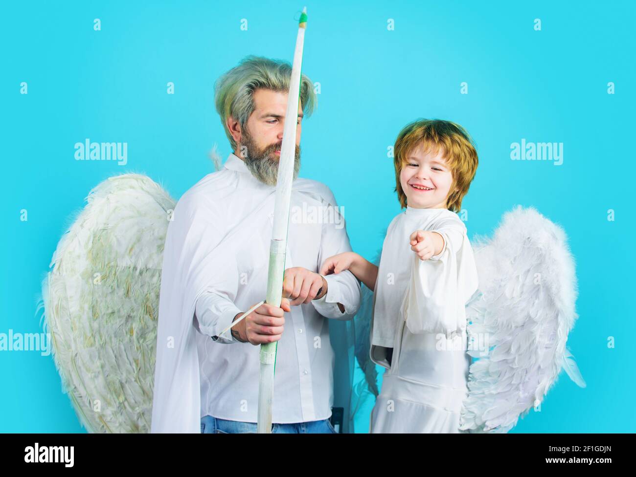 Valentines day angels. Little son and father with white wings. Father with little son in angel costume. Stock Photo