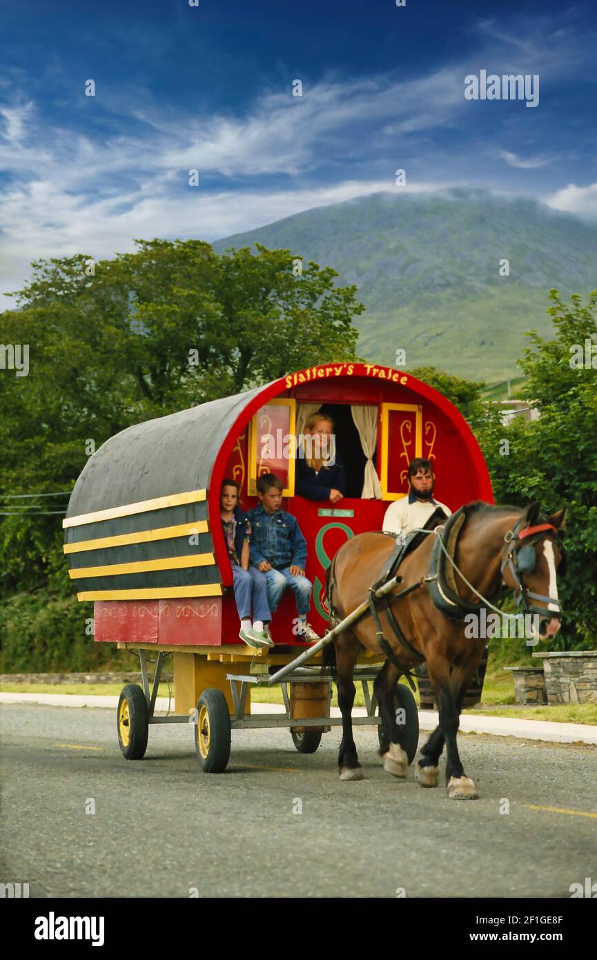 Irish travellers, move down a local road in their horse drawn caravan