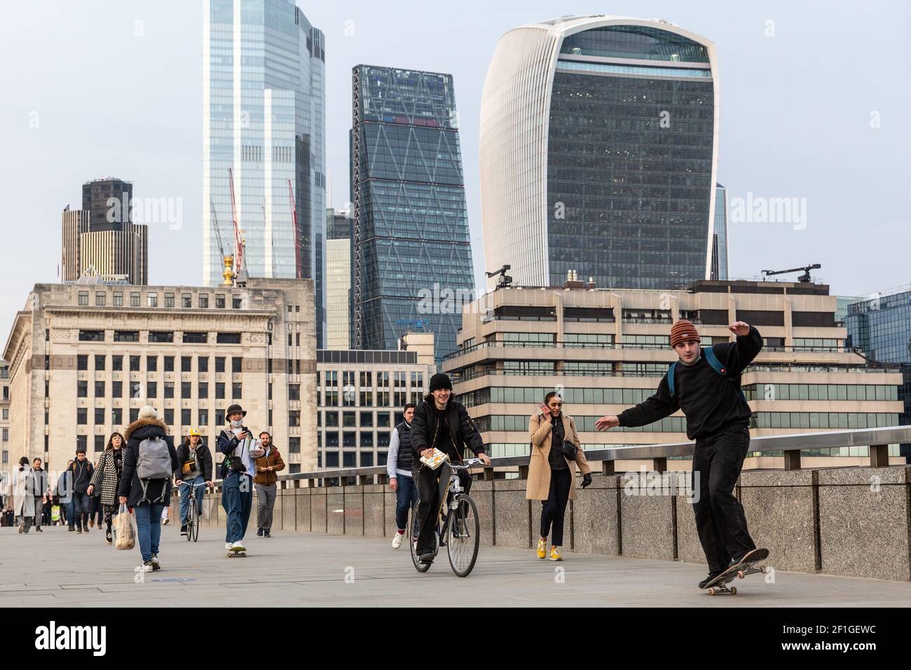 London, England on March 8, 2021. Commuters cross London Bridge while the setting sun covers The City of London, the financial hub of the UK during an ongoing third Coronavirus lockdown. The Prime Minister Boris Johnson has set a road map on easing the restrictions. Credit: Dominika Zarzycka/Alamy Live News Stock Photo
