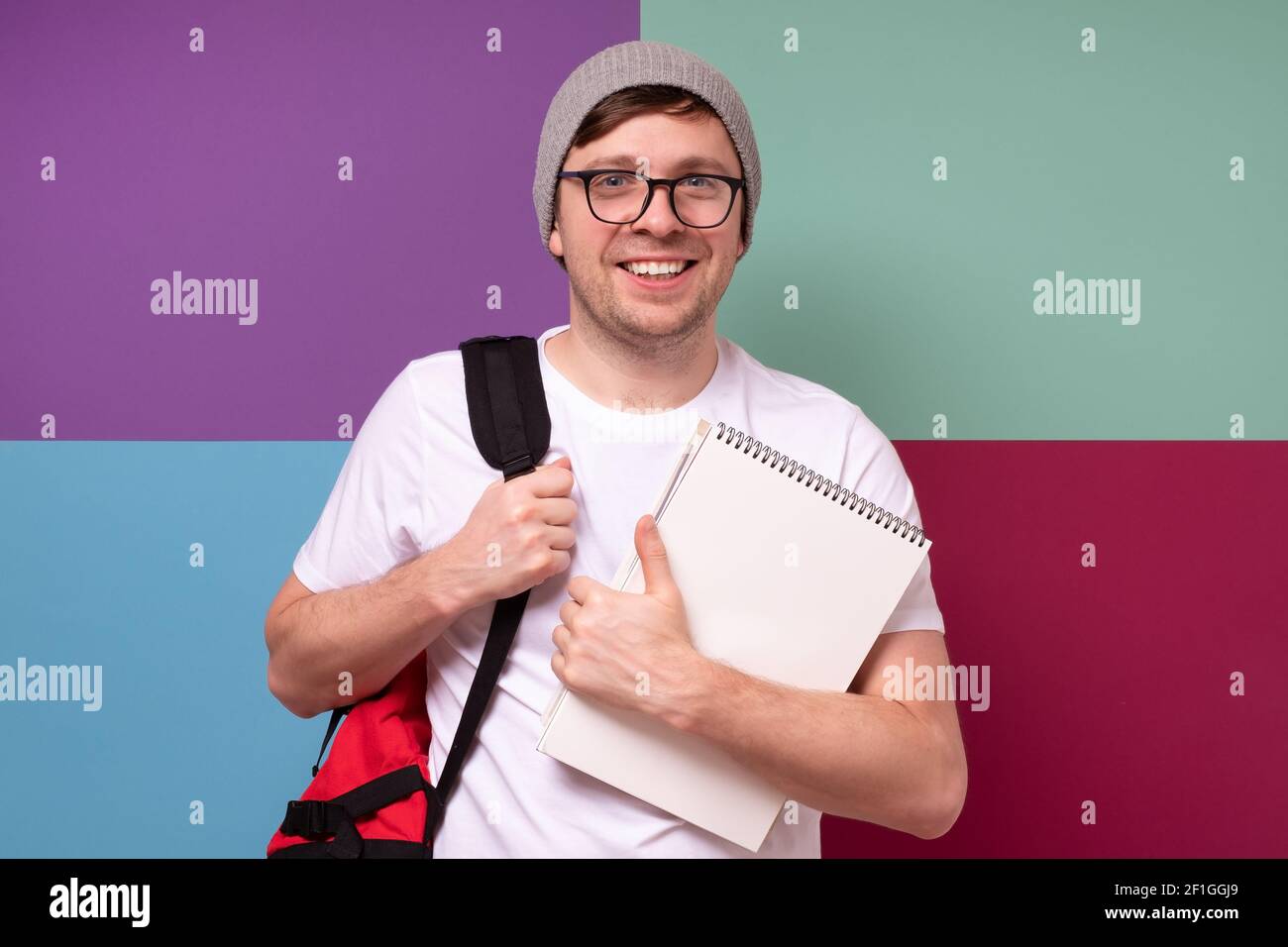 Young male student with glasses smiling ready for lessons. Studio shot ...