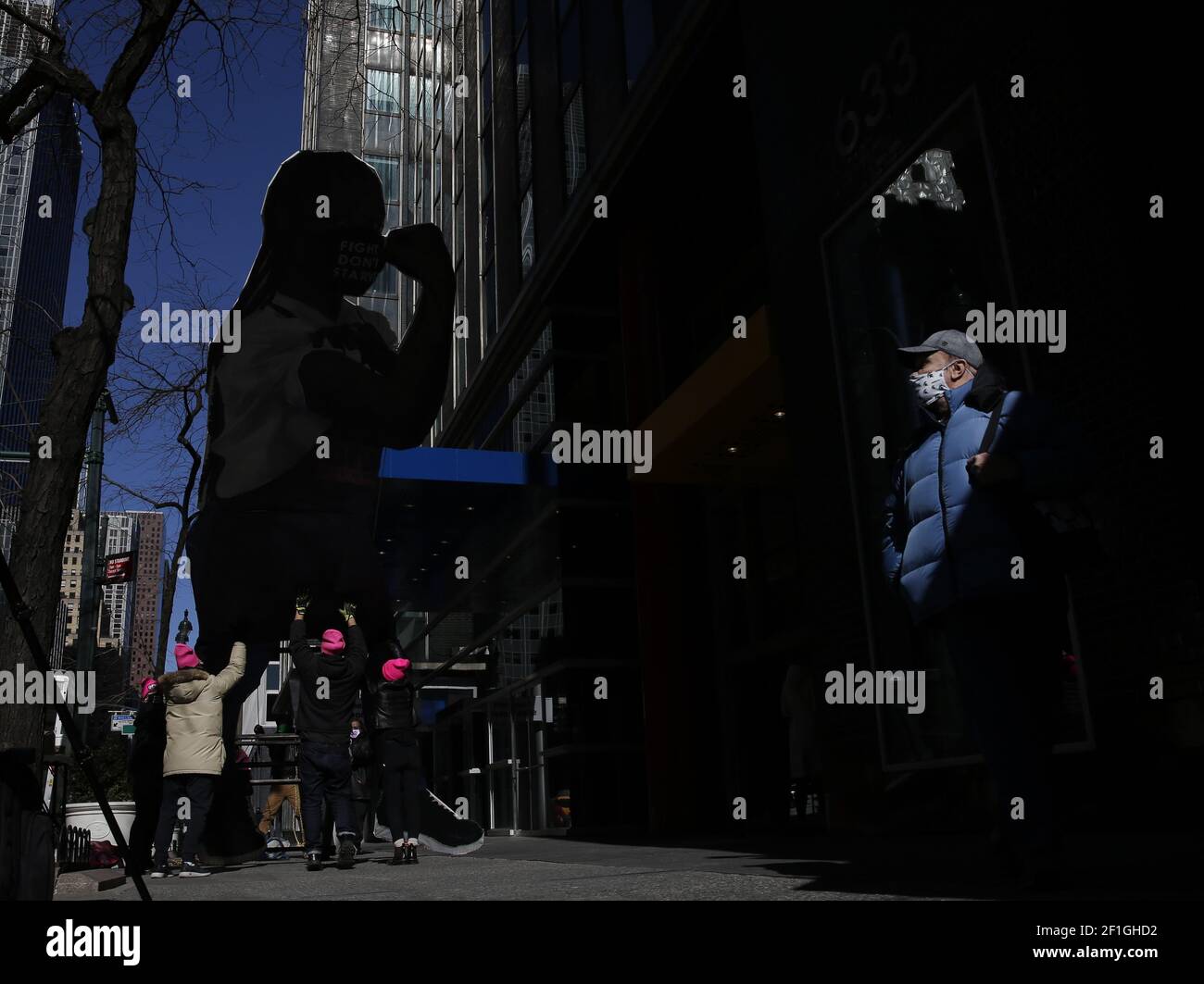 A man stops to watch as cardboard statue of a woman wearing a mask that says 'fight don't starve' is taken down after being on display at a women's march to hold women workers rising national day of action calling for a $15 Minimum Wage to coincide with International Women's Day outside of the Manhattan office of New York Gov. Andrew Cuomo in New York City on Monday, March 8, 2021. Also speakers asked for New York Gov. Andrew Cuomo's resignation after a fifth woman now has accused him of offensive behavior. Photo by John Angelillo/UPI Stock Photo