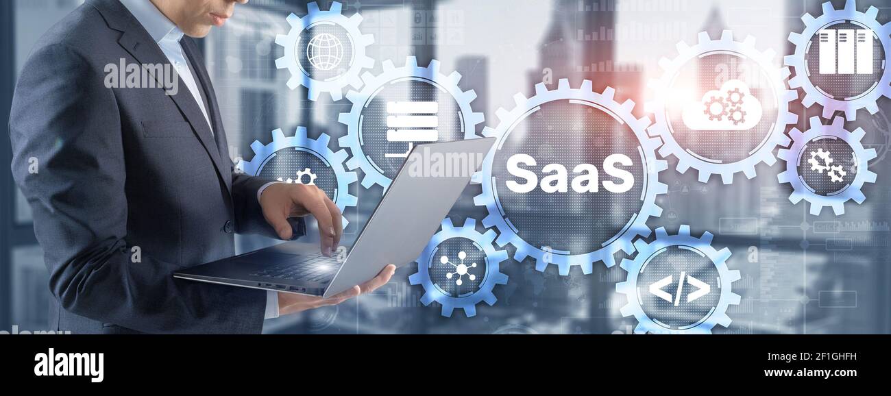 SaaS Software as a Service concept with hand pressing text. Stock Photo