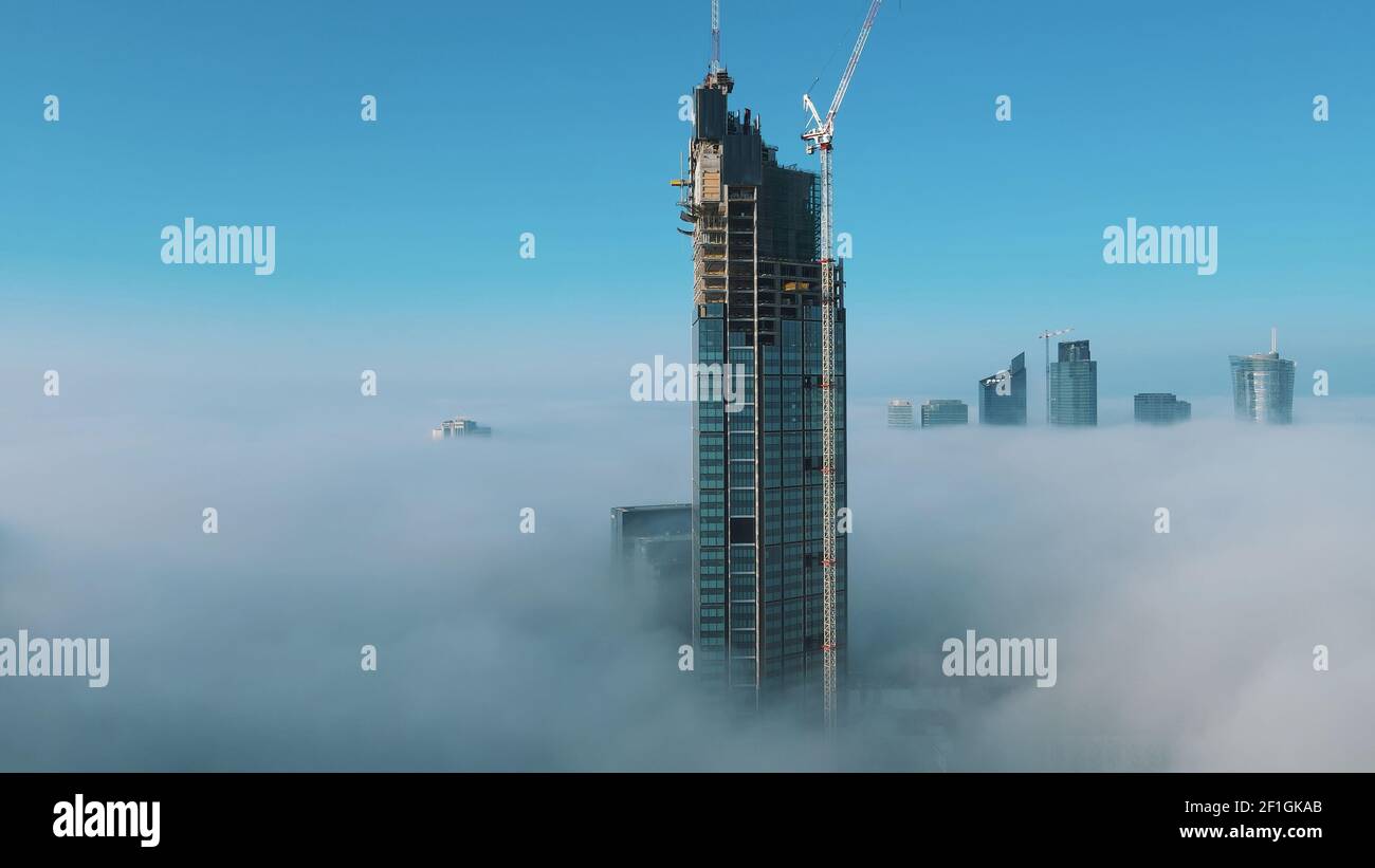 Astonishing aerial view of top of the Varso Tower under construction rising above clouds. High quality photo Stock Photo