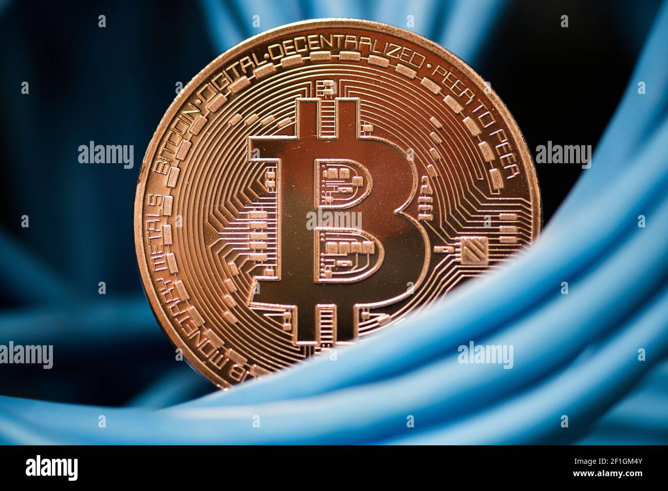 Cryptocurrency, digital curency, bitcoin mining concept. Golden bitcoin  simbol in cables closeup Stock Photo - Alamy