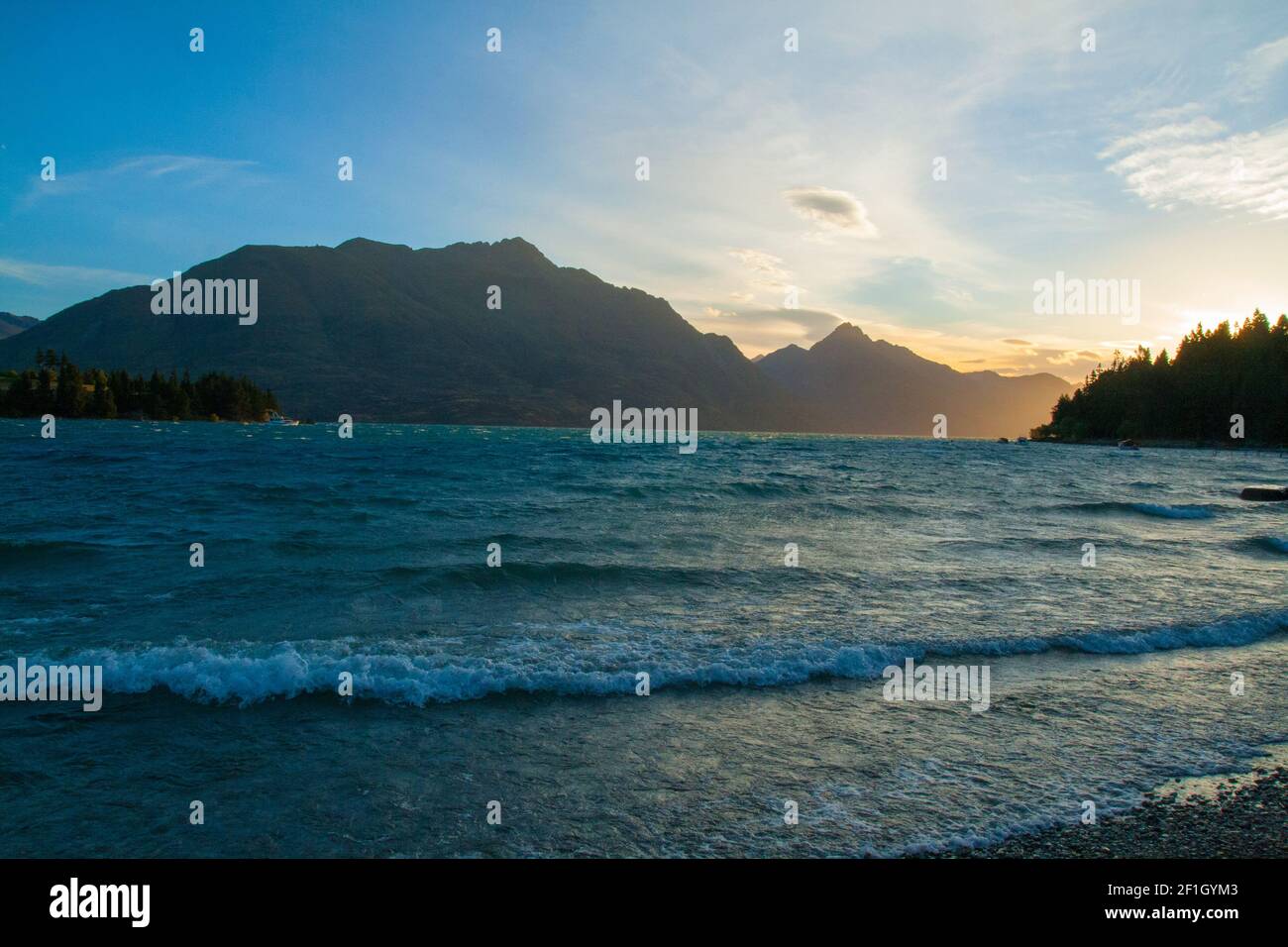Wilson Bay near Queenstown, South Island New Zealand, the view of Lake Wakatipu, Cecil and Walter Peak, golden setting sun afternoon Stock Photo