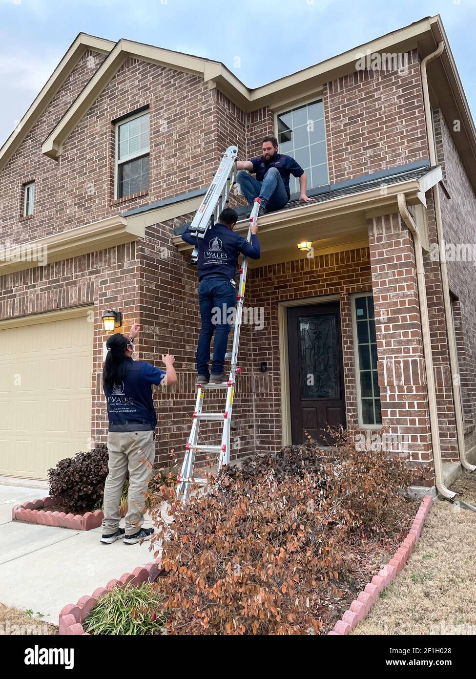 Mckinney, TX USA - March 1, 2021: Roof inspector climbing up to the roof to check the damage after hail Stock Photo