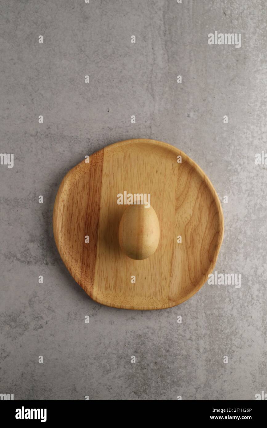 wooden egg on a wooden plate Stock Photo