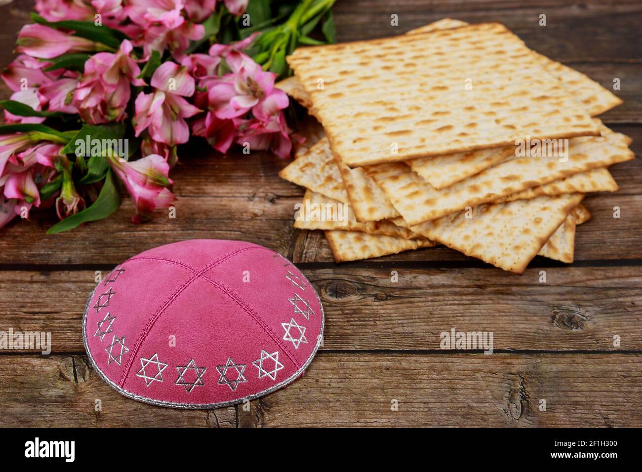 Jewish matzah bread with kippah and flowers on wooden rustic background ...