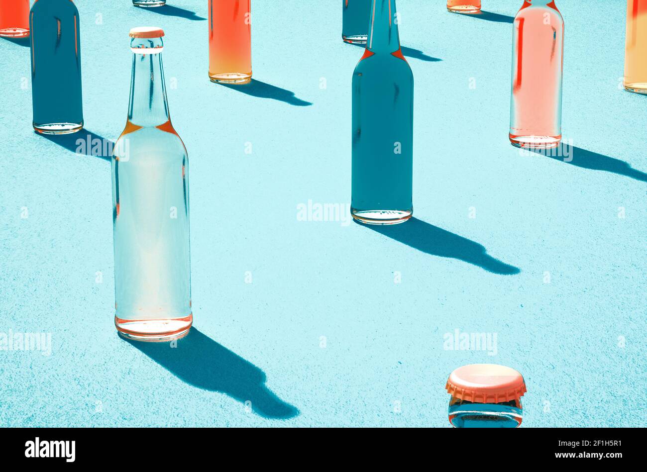 3d mockups of glass beer bottles with caps and without labels. Shadows on light blue surface. Retro drink bottle concept. Stock Photo