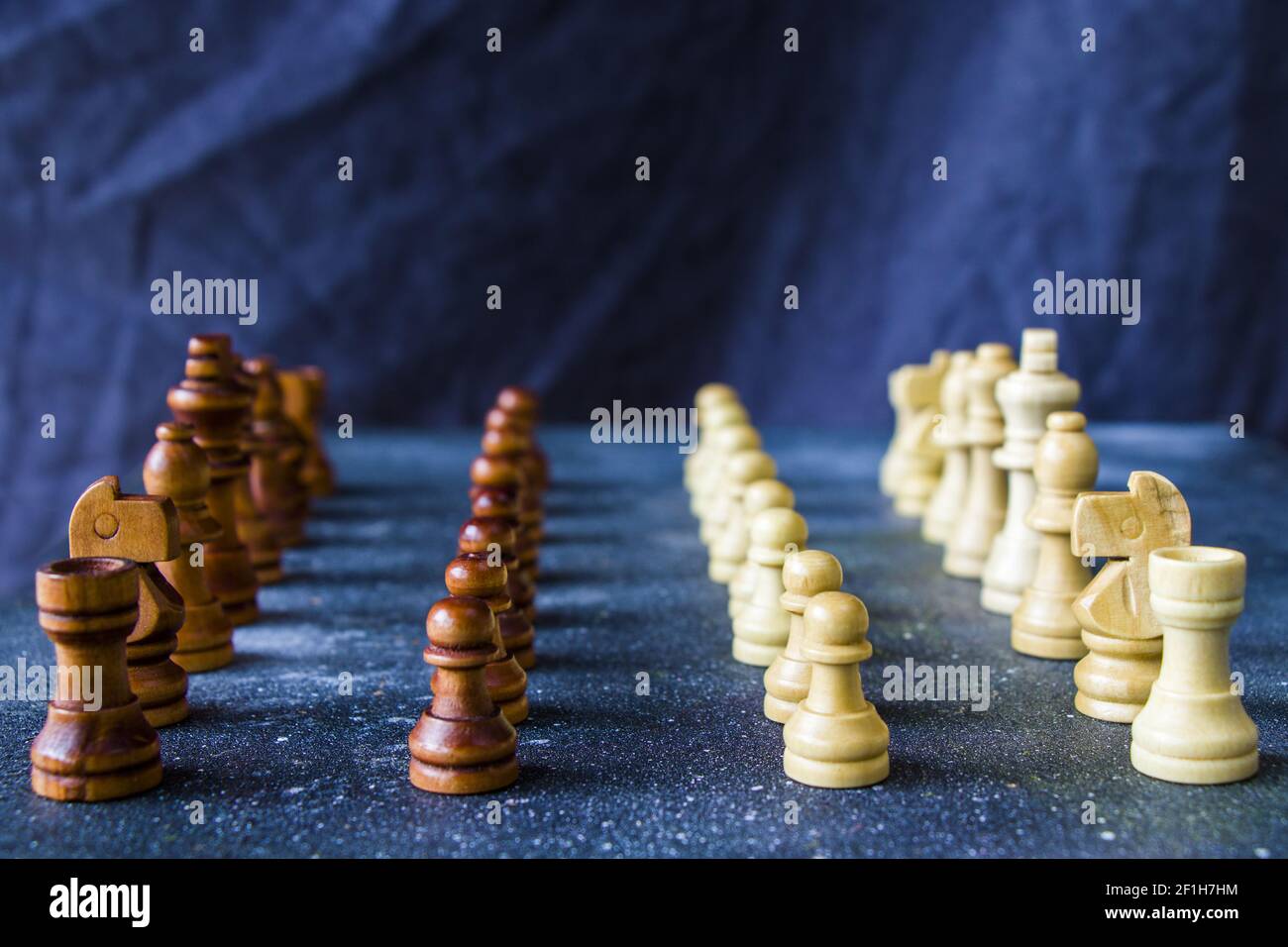 A side view of wooden chess figures arranged in starting position on a ...