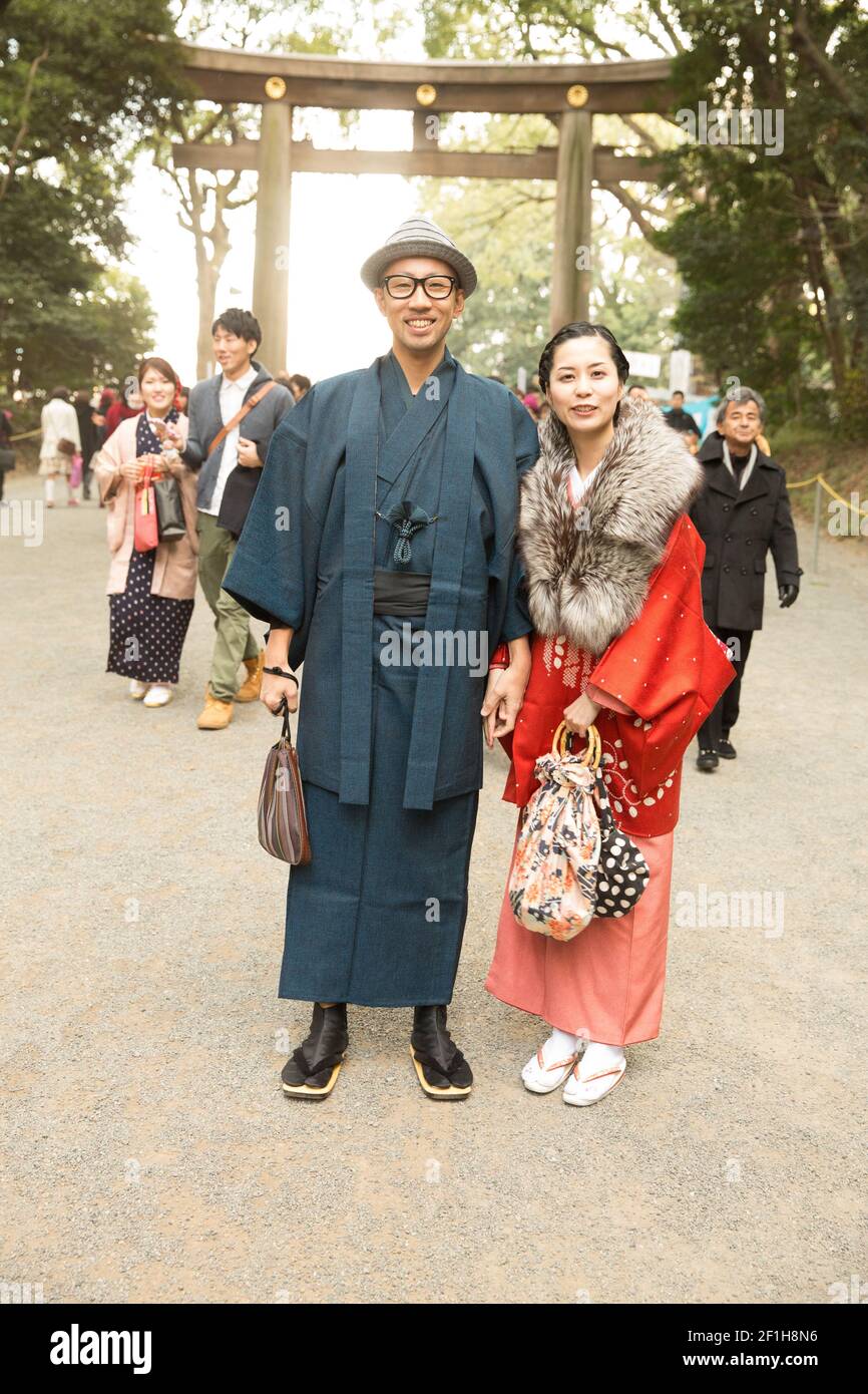 japanese new year dress Japanese woman in traditional kimono dress is making a new year wish for good fortune while walking in the park at cherry blossom tree during spring sakura festival with copy space |