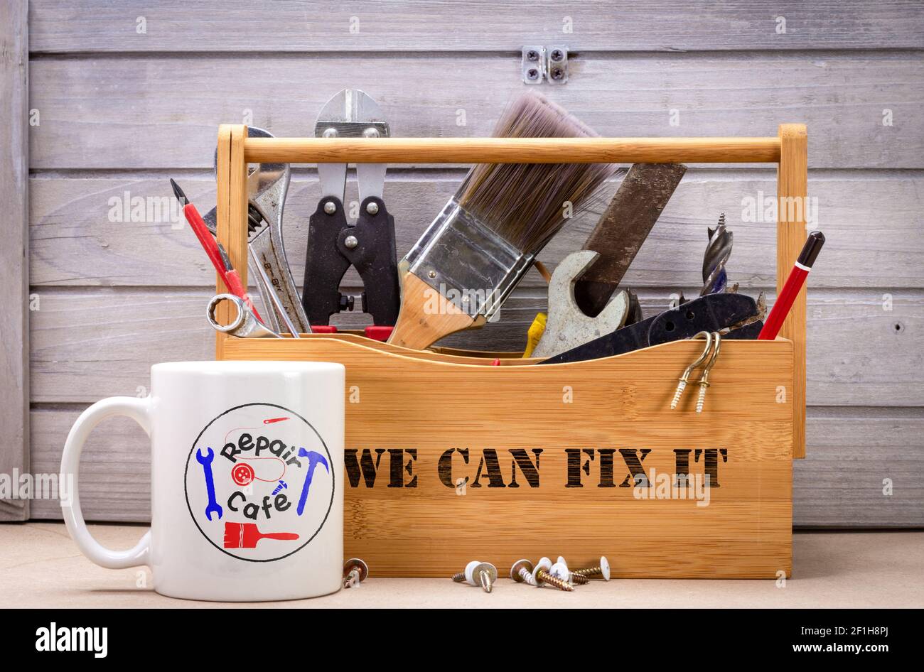 Repair Cafe logo on mug with box of repair tools, we can fix it text, consumer activism to repair household items to reduce waste and support a sustai Stock Photo