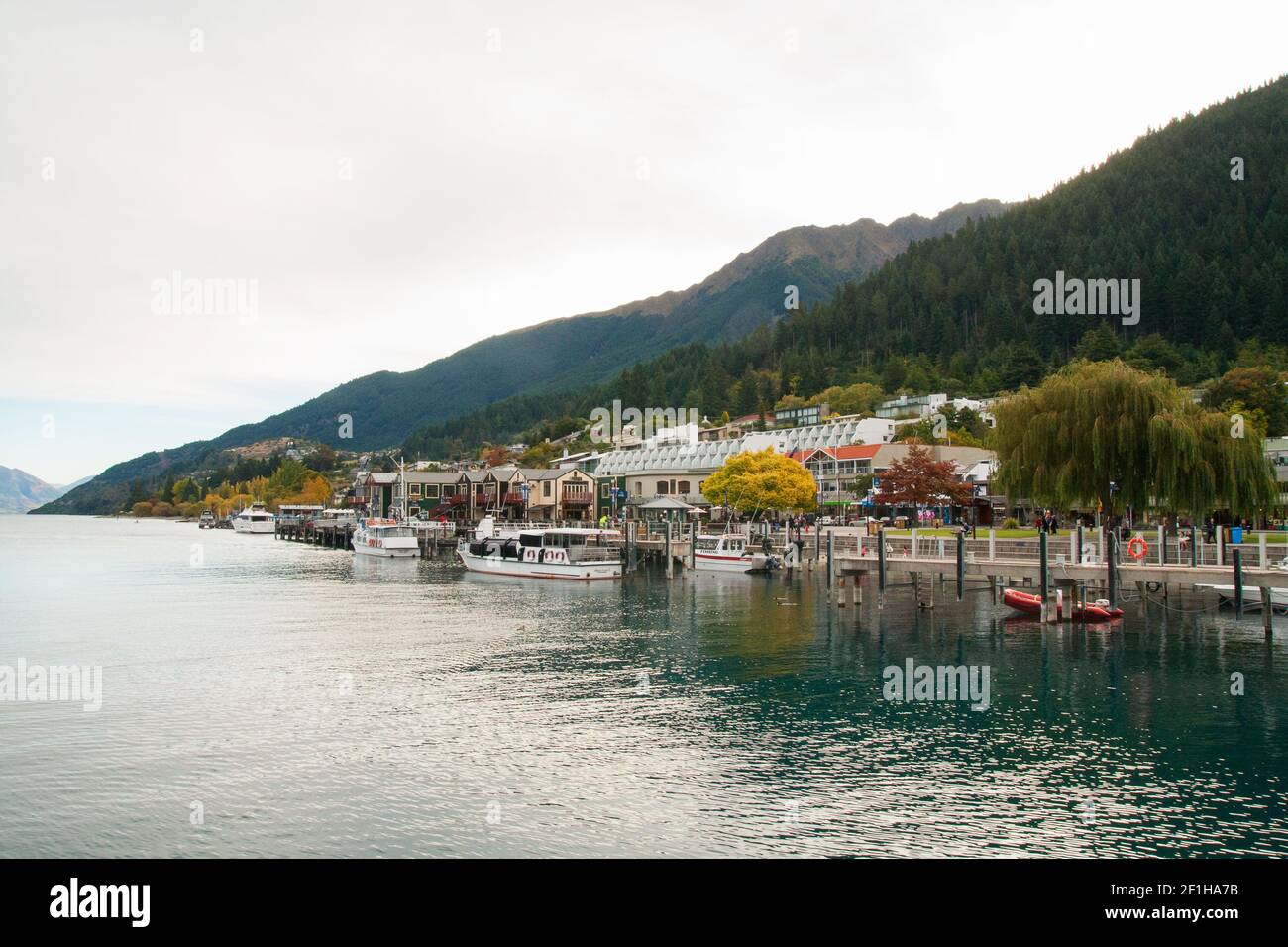 Lake Wakatipu and Queenstown harbour New Zealand, dock boats and lakeside promenade Stock Photo