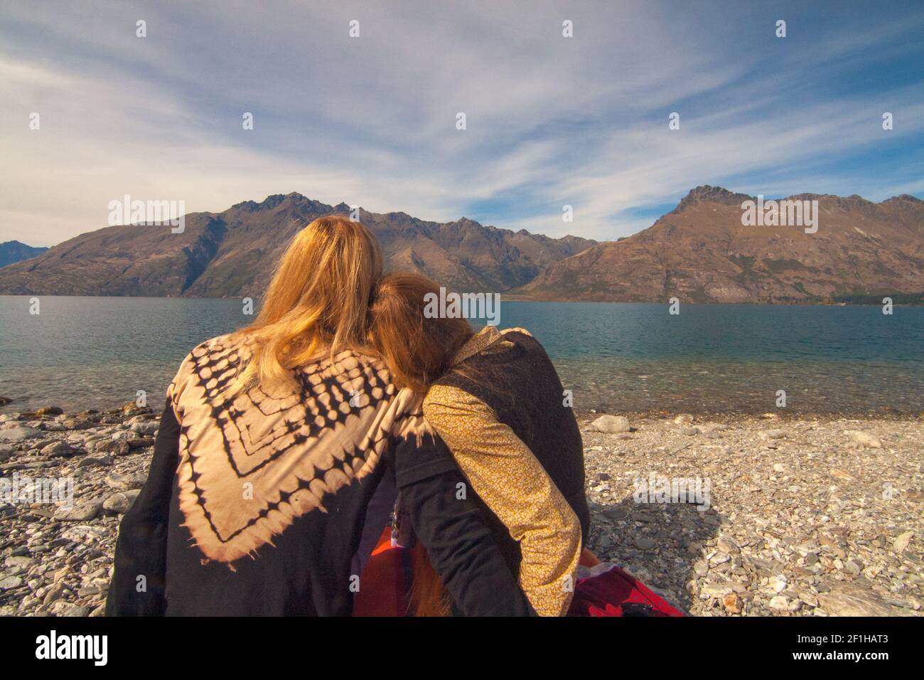 Back view of romantic couple snuggle at Wilson Bay near Queenstown, South Island New Zealand Stock Photo