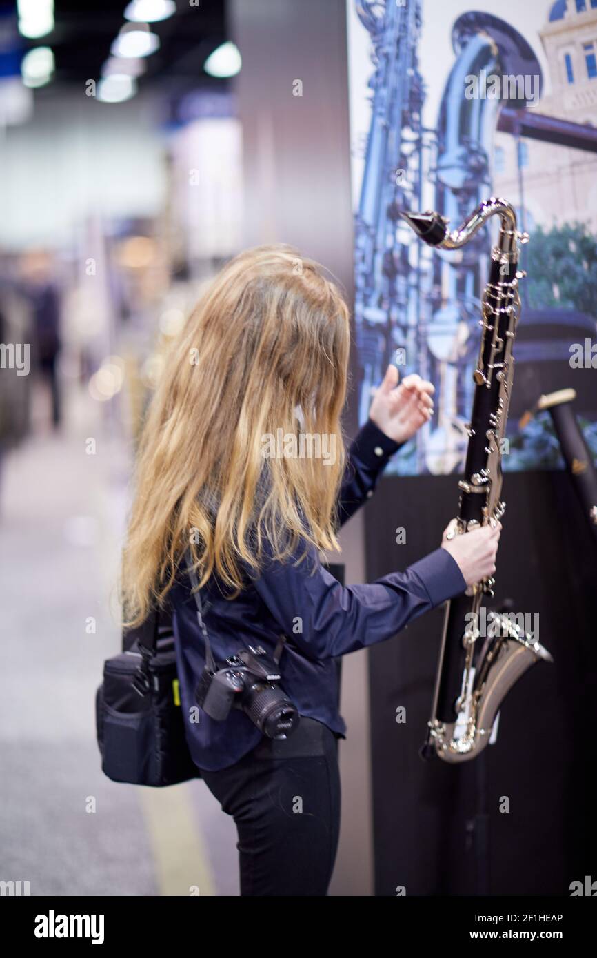 Woman inspecting bassoon at Musical Instrument Convention Stock Photo